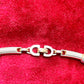 Lobster clasp signed Vintage Christian Dior two-tone necklace with ribbed accents displayed on a red velvet background