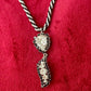 Close up on vintage Christian Dior rhinestone pendant with Trifari necklace against a red background 