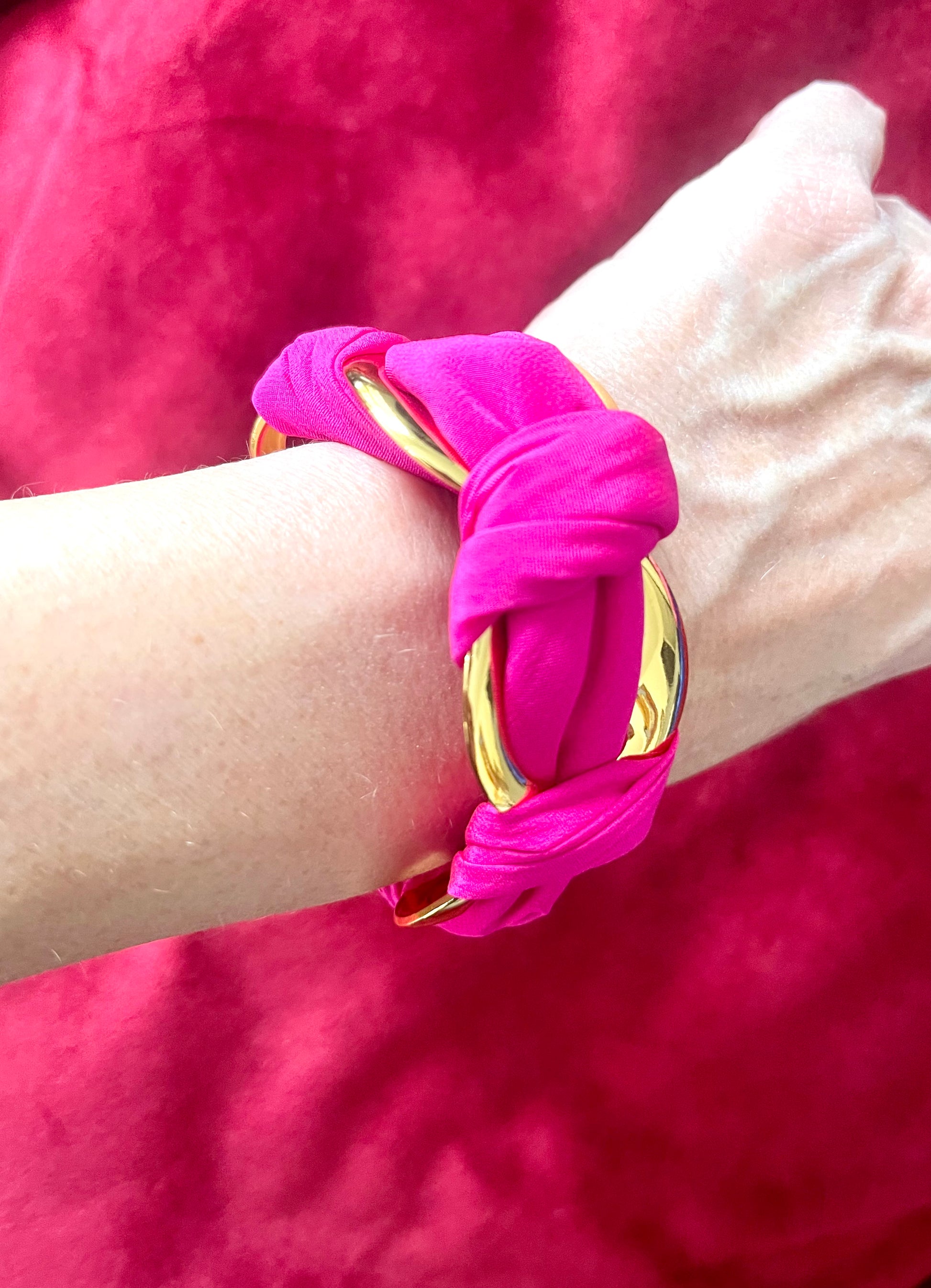 Worn in hand Gold-plated stainless steel bracelet with vintage Dior silk scarf wrapped with a red background 