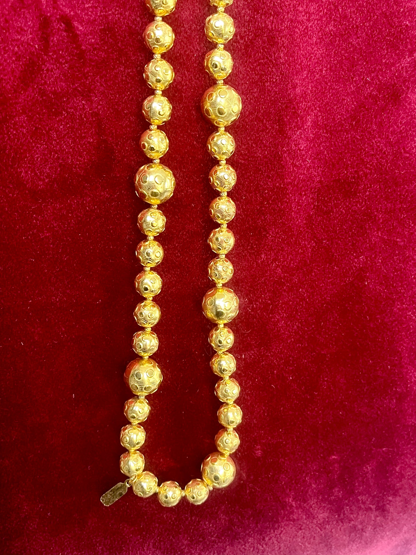 Close-up of YSL vintage gold bead necklace showing 18K refurbished shine and textured detailing with tag shown vintage Yves Saint Laurent 
