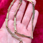 Back side on skin tone Vintage Christian Dior two-tone necklace with ribbed accents displayed on a red velvet background