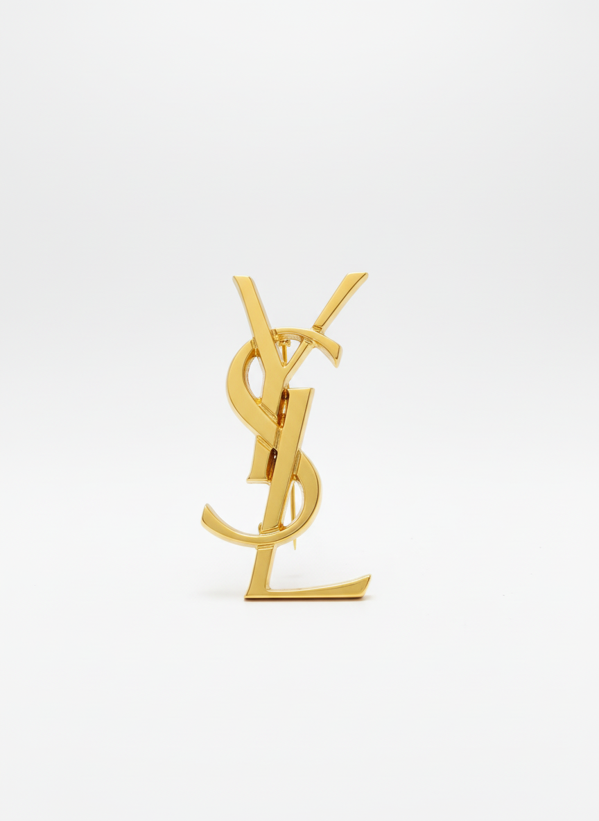 YSl gold pin brooch on white bacj