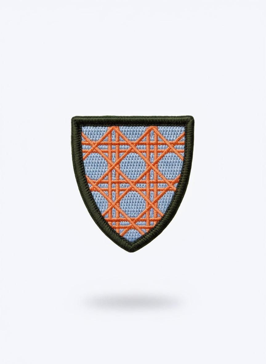 Dior pin with orange and blue geometric pattern on a light blue background