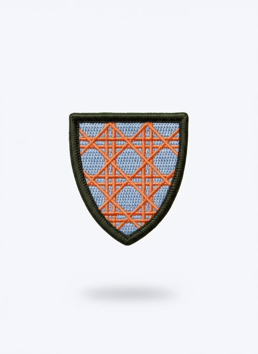 Dior pin with orange and blue geometric pattern on a light blue background