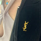 Broche Yves Saint Laurent con letras en tono dorado